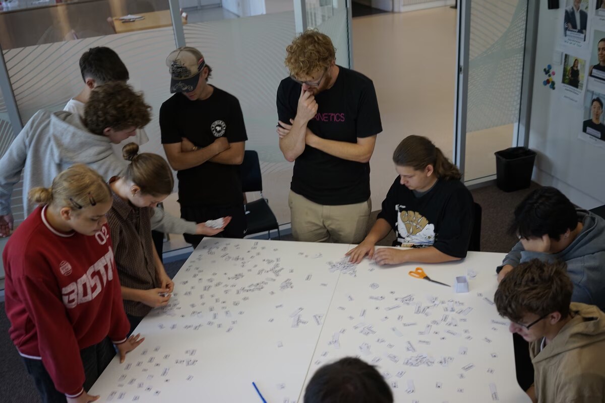 Autumn School students and Ben gathered around a table covered in word tokens